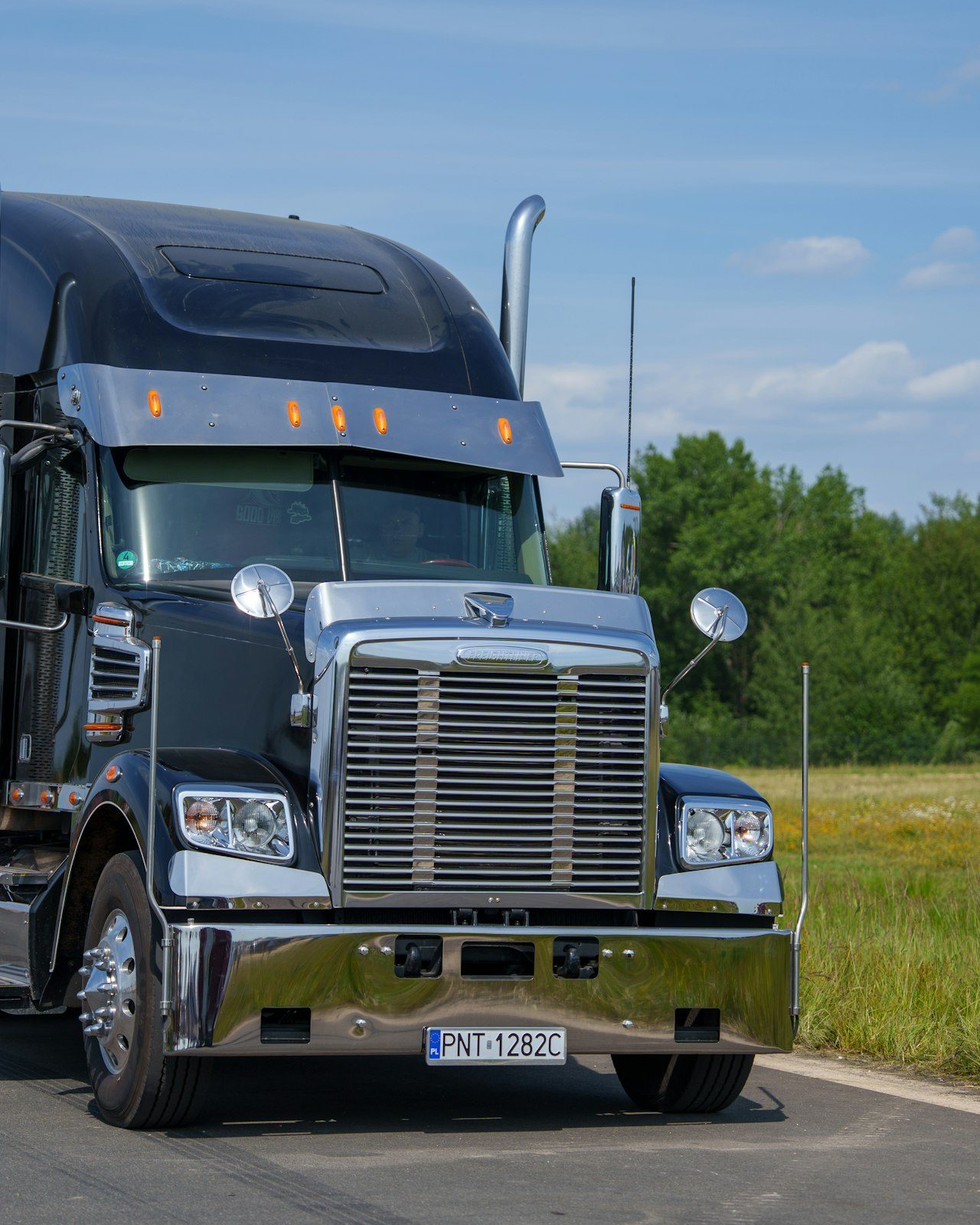 Black semi truck on a rural road