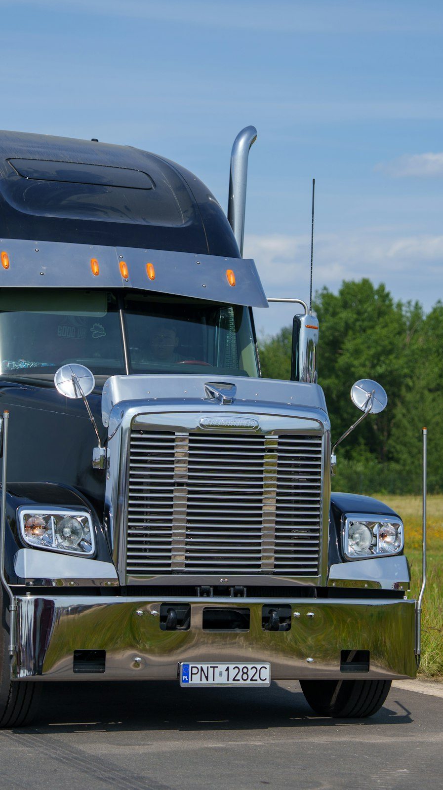 Black semi truck on a rural road